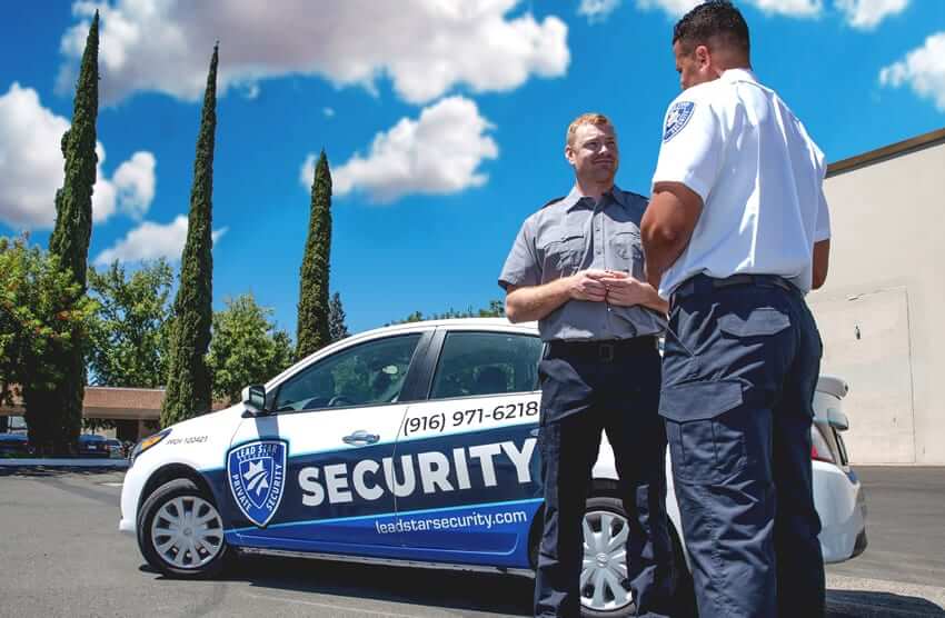 Security guards standing next to mobile patrol car with 916 area code